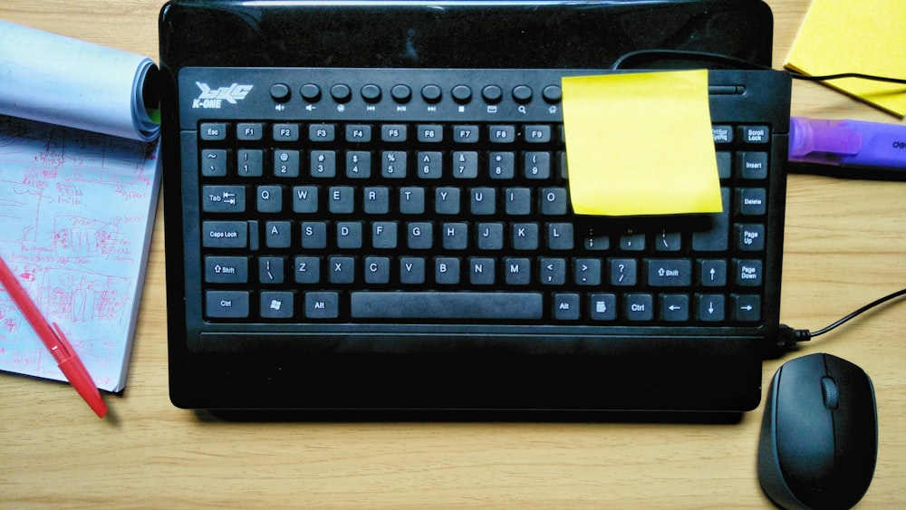 black logitech keyboard on brown wooden table