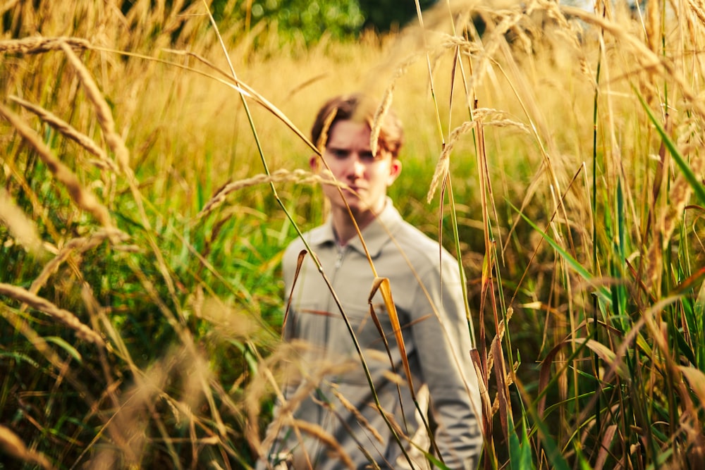 man in grey crew neck long sleeve shirt standing on green grass field during daytime