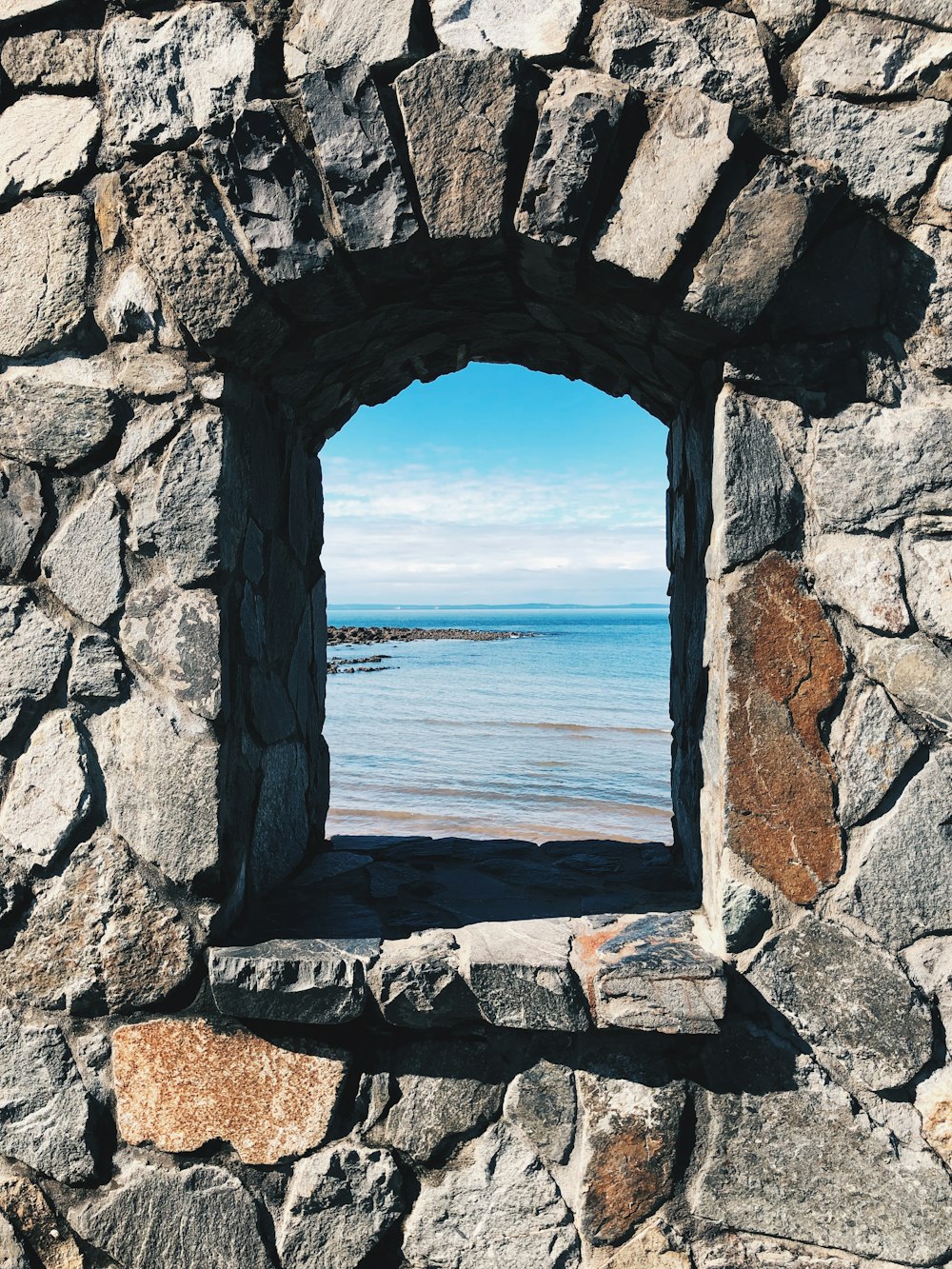 gray concrete arch near sea during daytime