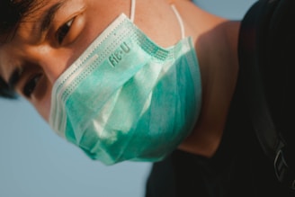 Close-up of a sleek medical face mask with green accents on a dark background.