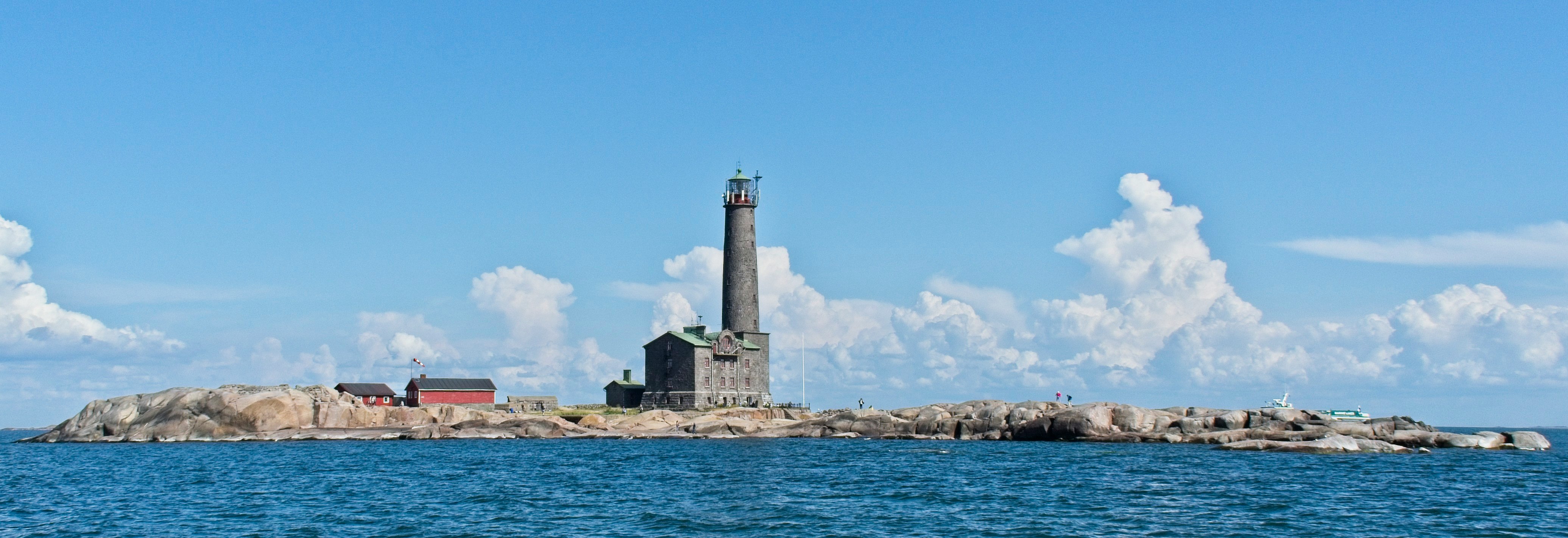 white lighthouse near body of water during daytime