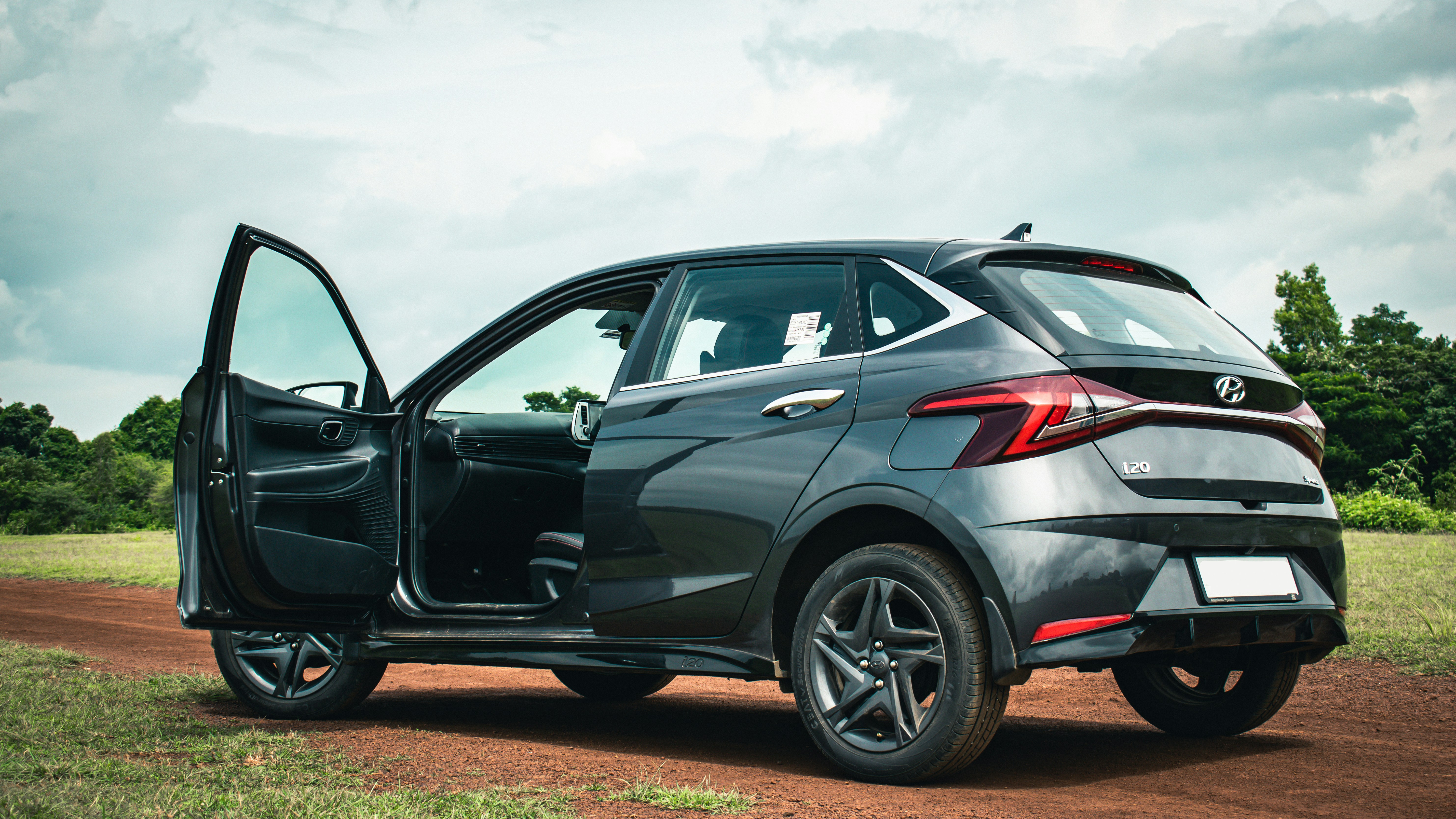 A Blue Hyundai on a dirt road on a sunny and glimmering day 