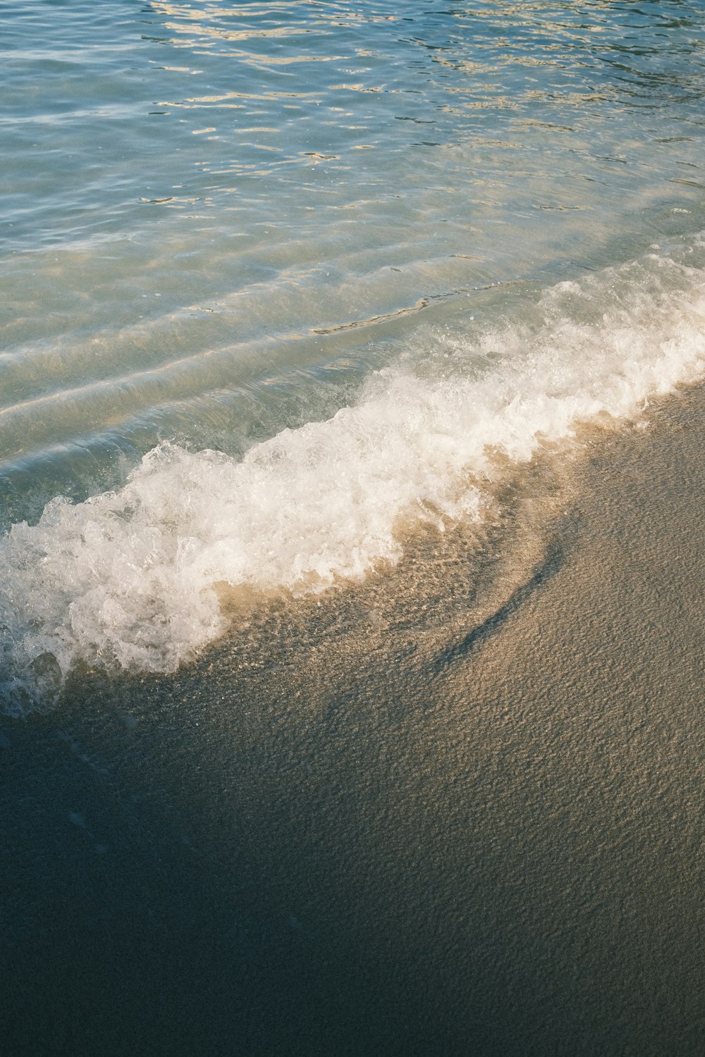 ocean waves on brown sand during daytime