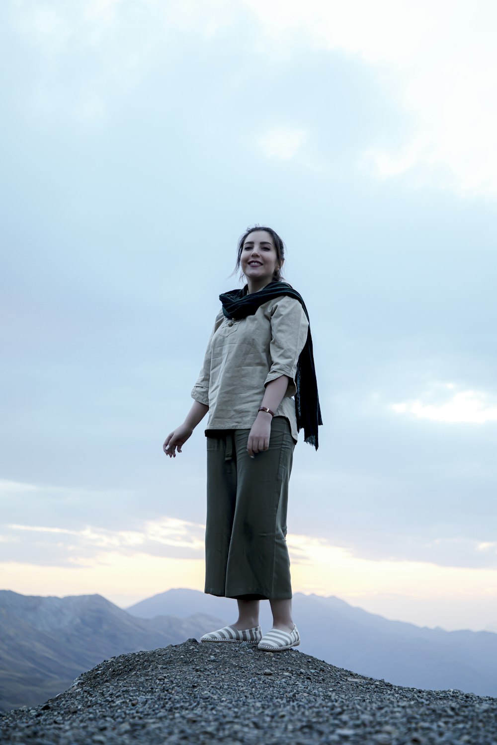 woman in black coat standing on top of mountain during daytime