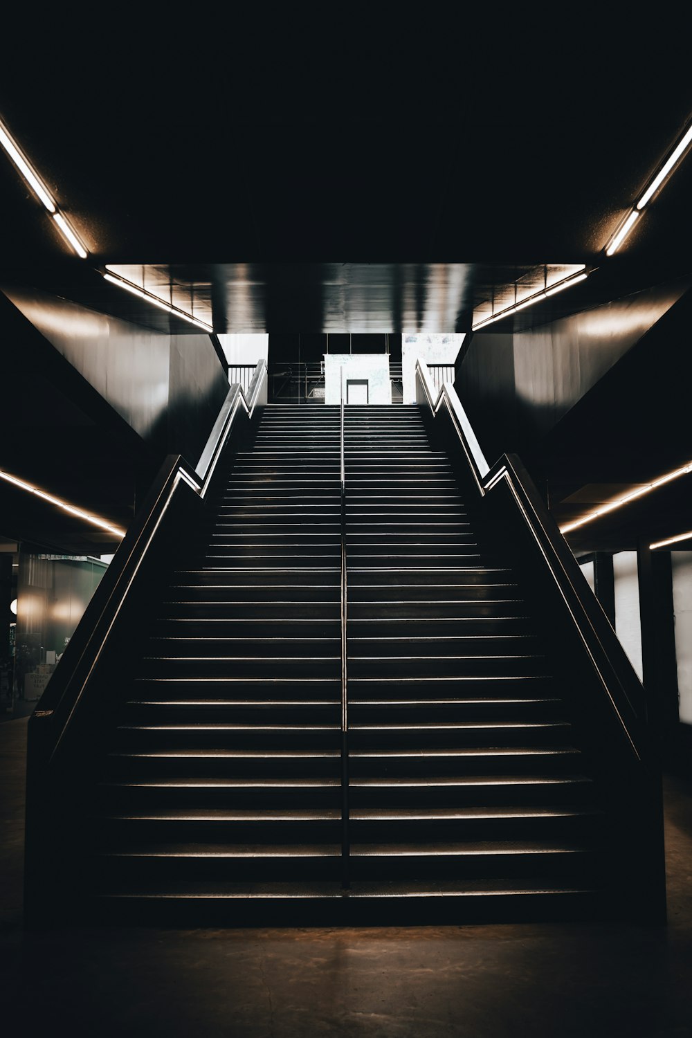 black and white staircase with stainless steel railings