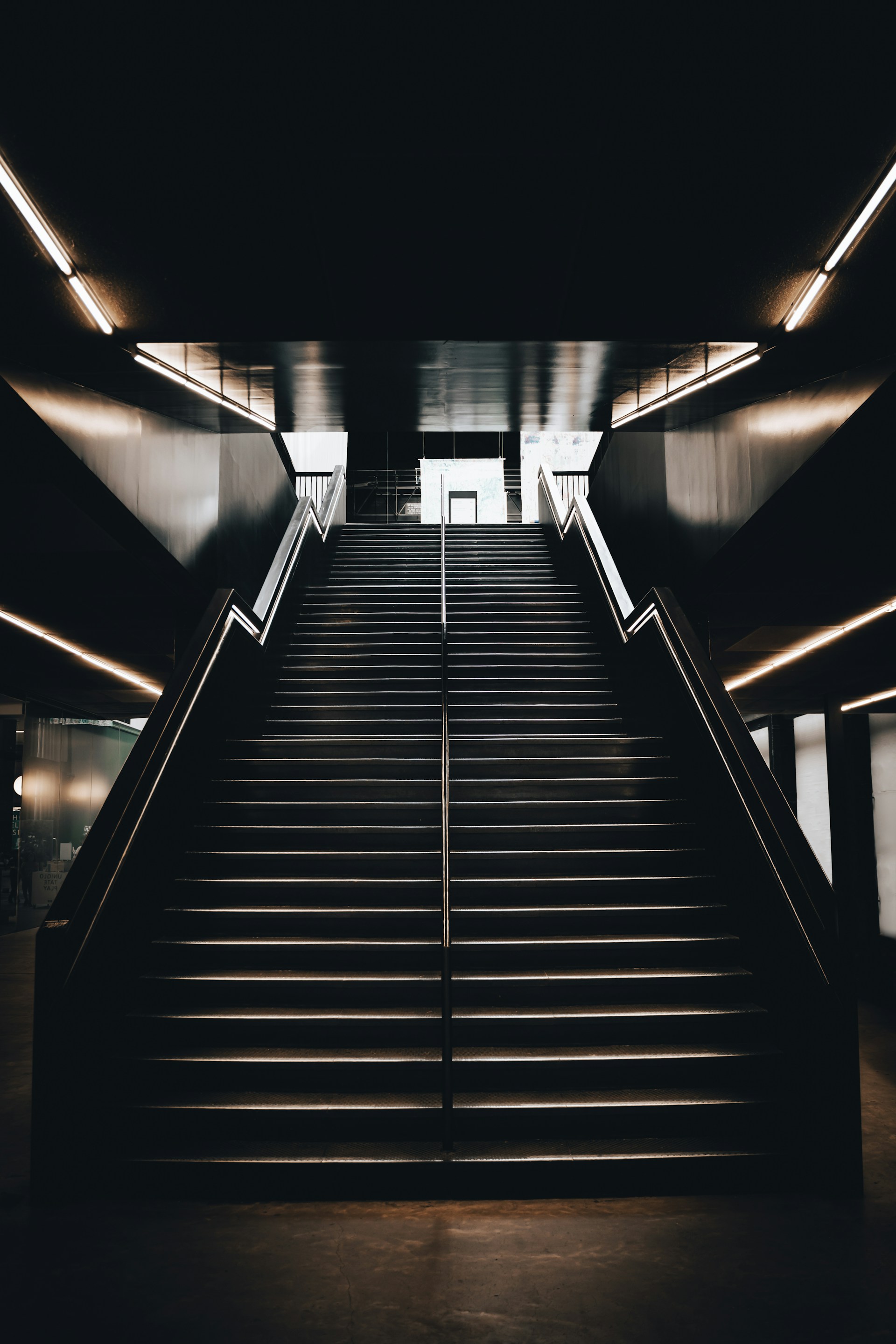 black and white staircase with stainless steel railings