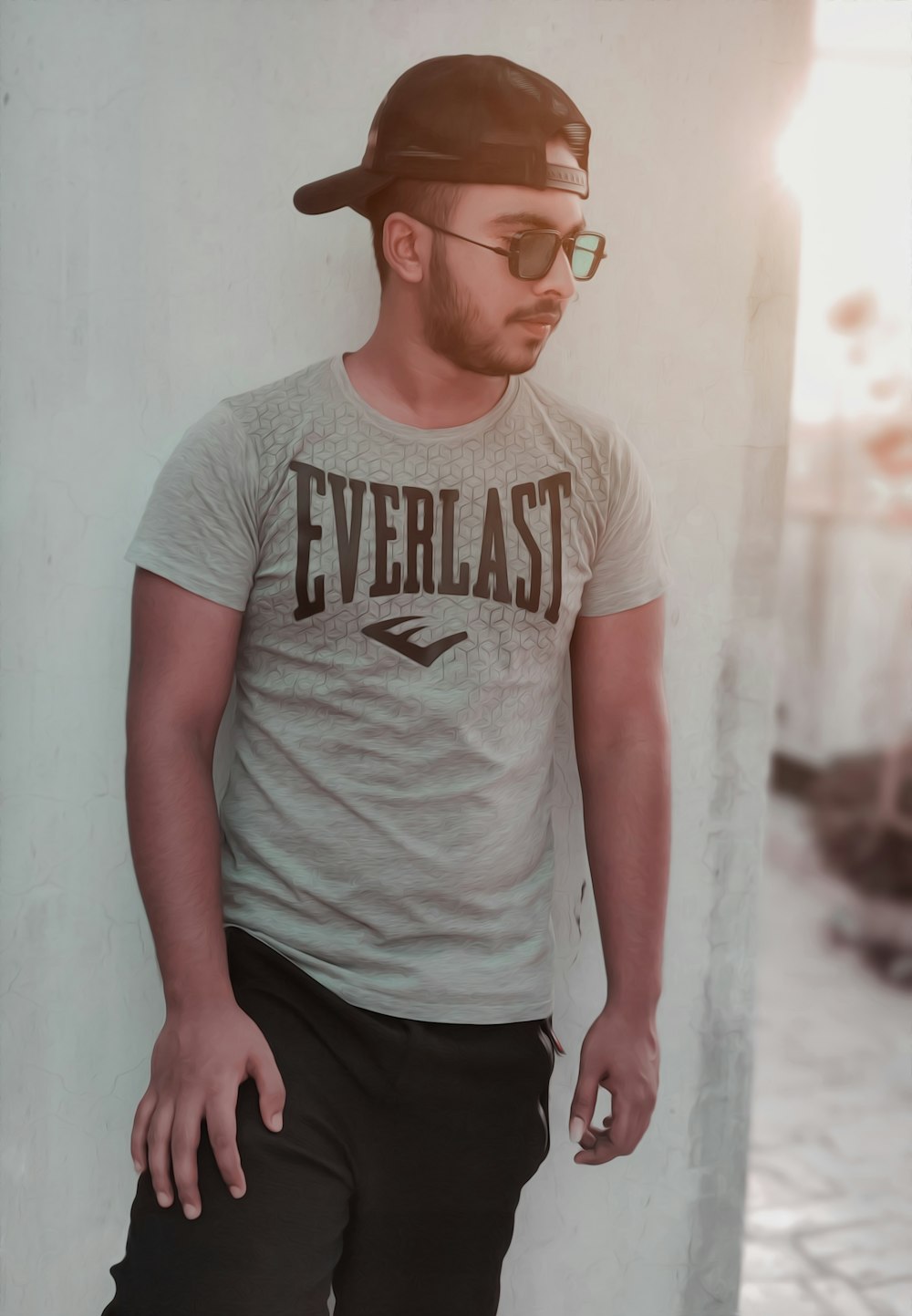 man in gray crew neck t-shirt and black pants standing beside white wall