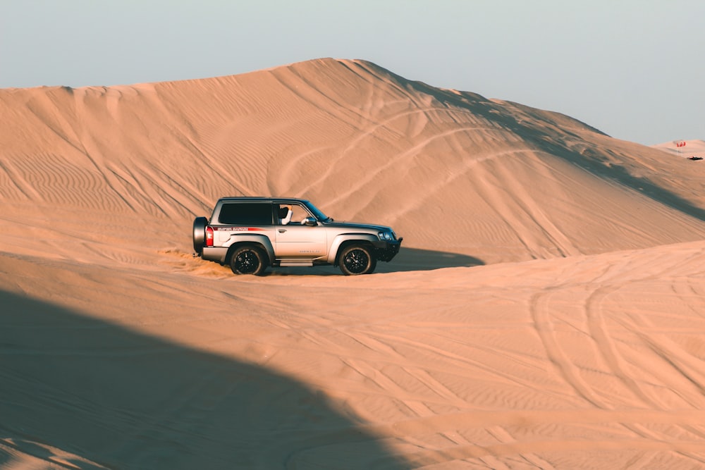 white and black suv on desert during daytime