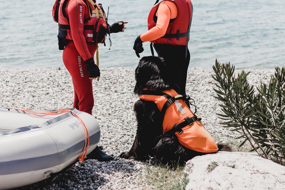person in orange life vest holding white and orange surfboard