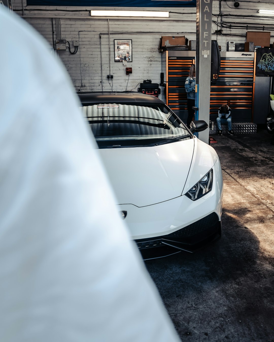 white car parked near brown brick building