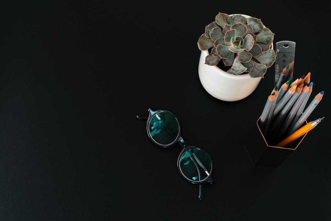 silver framed eyeglasses on white ceramic vase