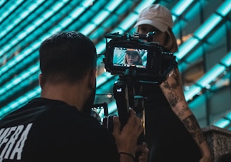 man in black shirt holding black dslr camera