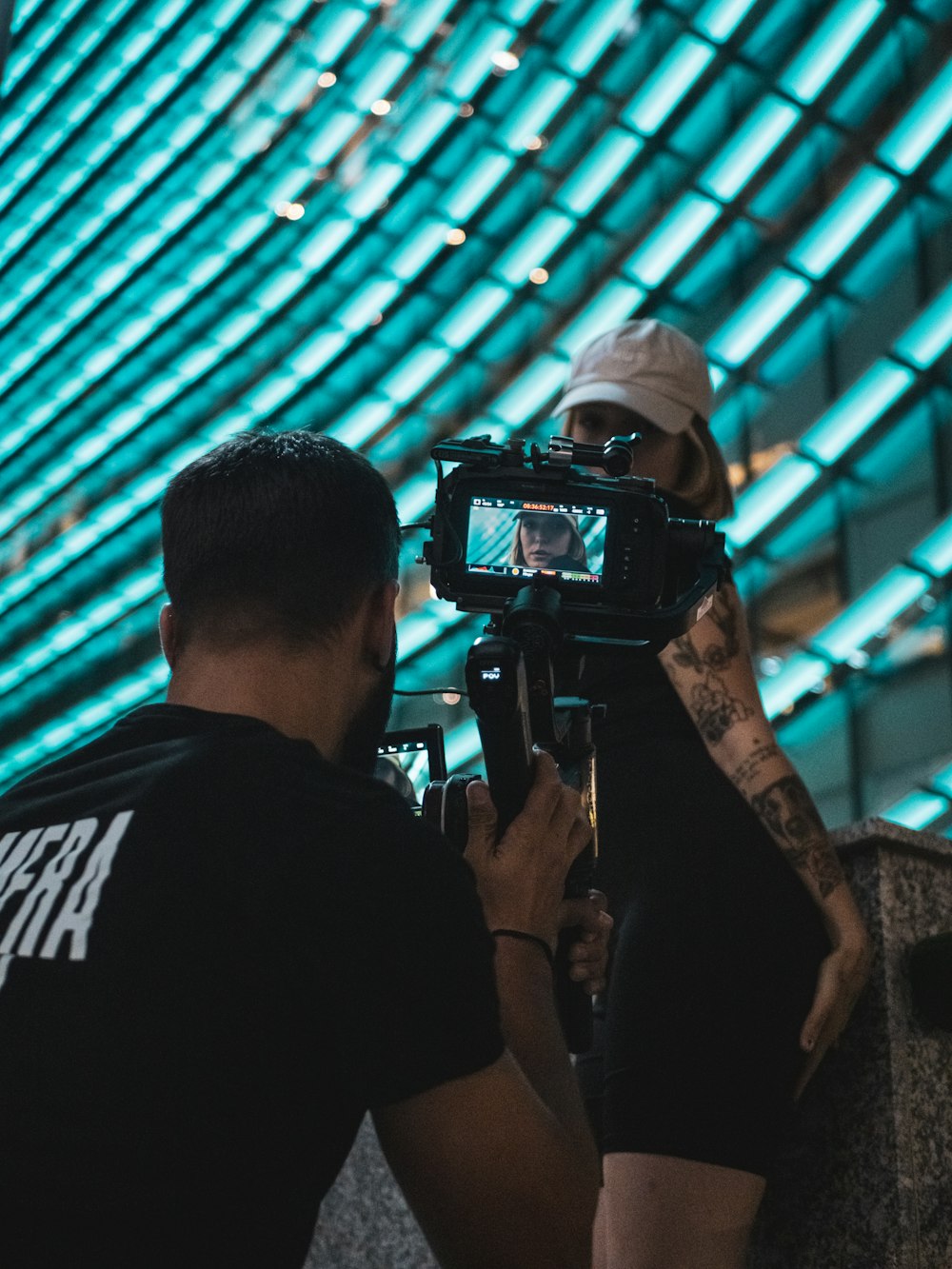 Hombre con camisa negra sosteniendo una cámara DSLR negra