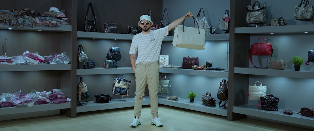 man in white crew neck t-shirt holding black leather handbag