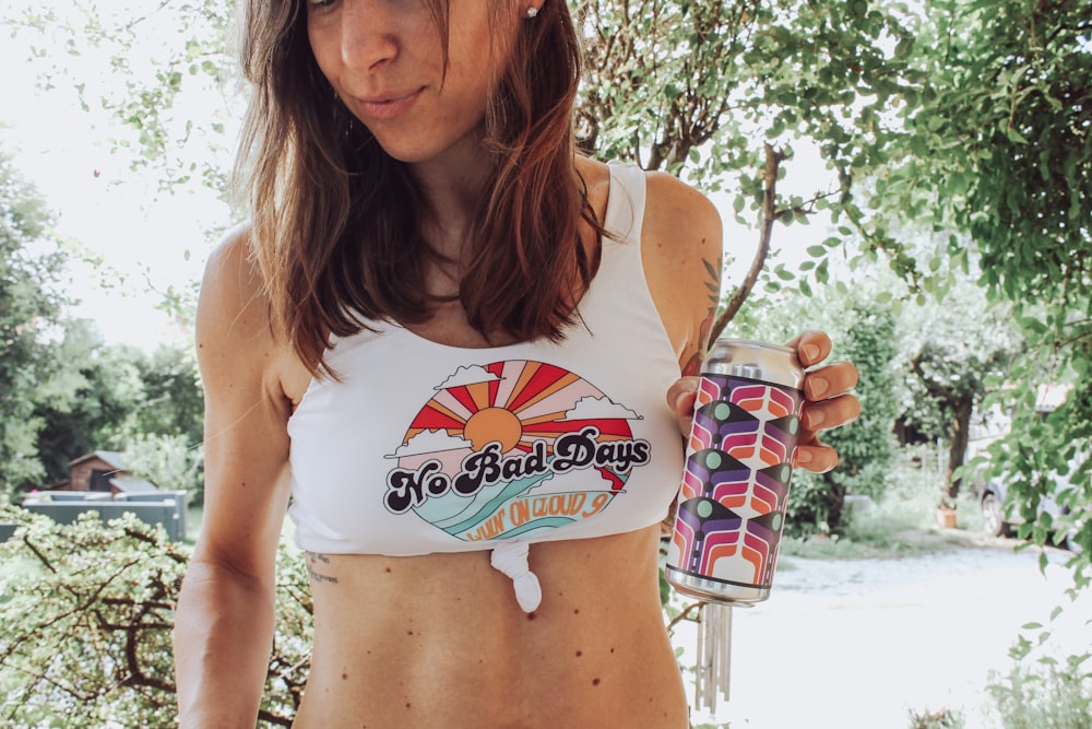 woman in white tank top holding a cup of ice cream