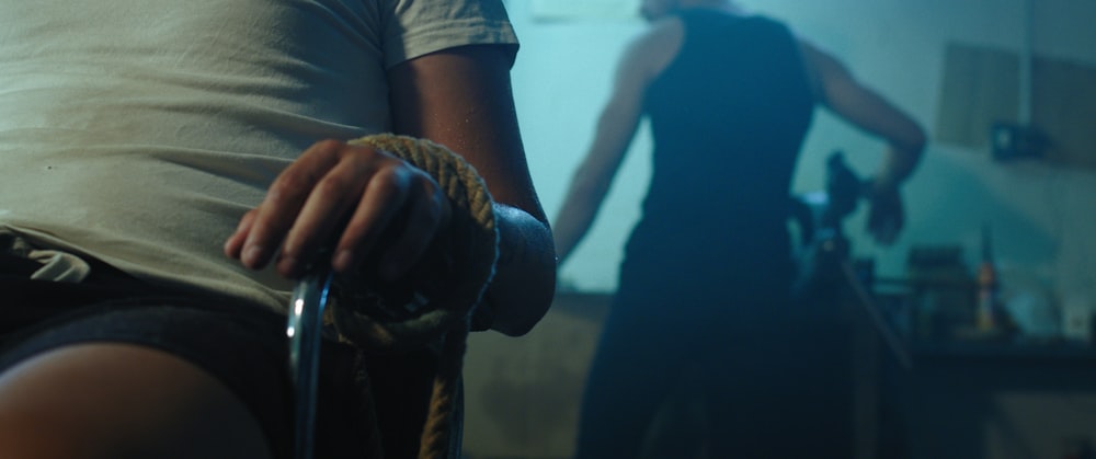 Hombre con camiseta negra sosteniendo serpiente marrón y negra