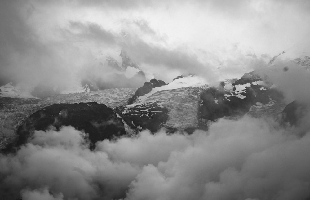 grayscale photo of mountains covered with clouds