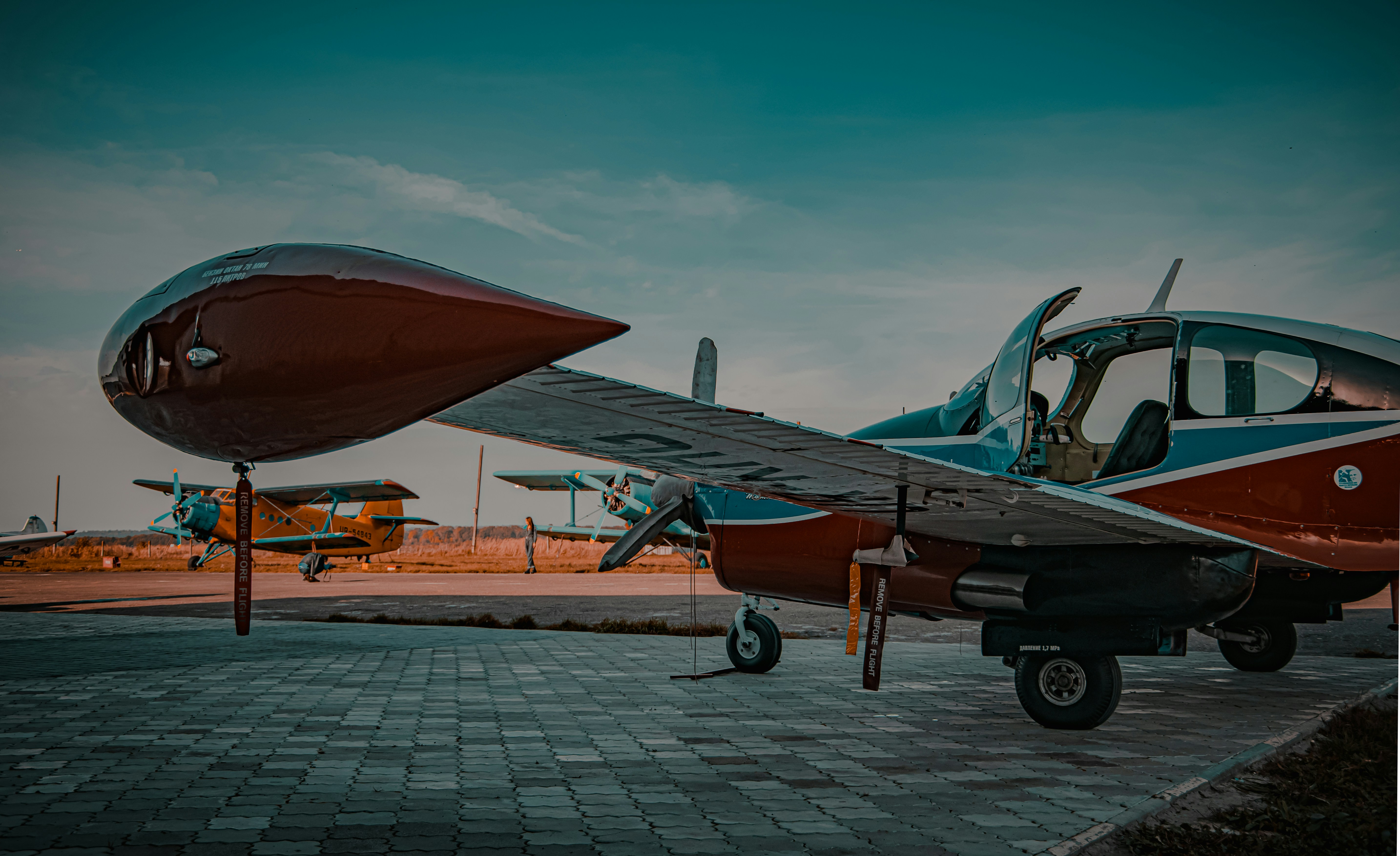 schwarz-orangefarbenes Düsenflugzeug auf braunem Ziegelboden