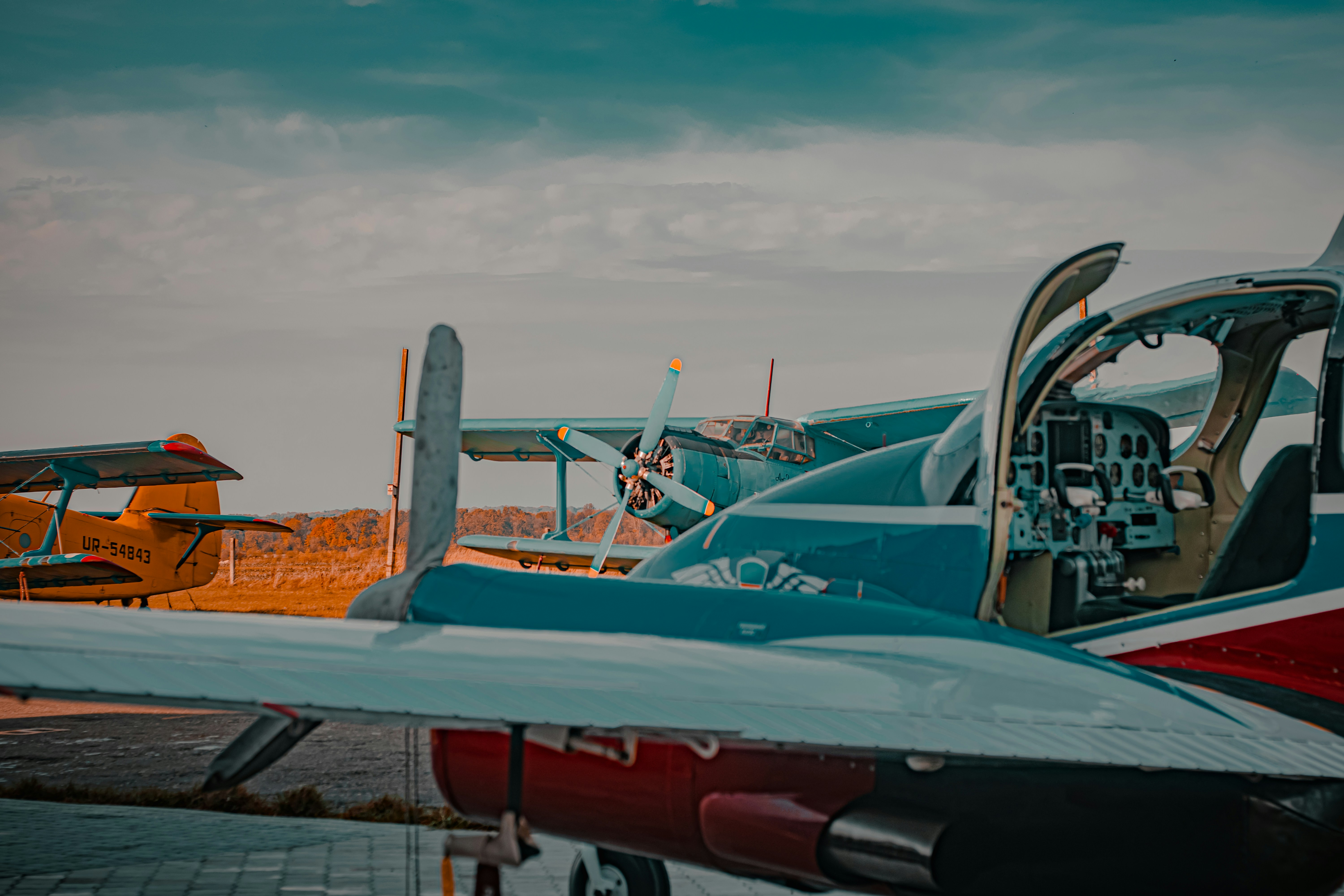 Weiß-rotes Flugzeug tagsüber unter bewölktem Himmel