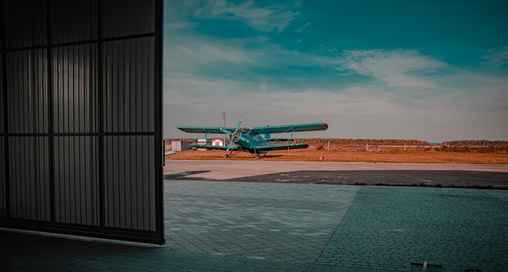 green and white airplane on gray concrete ground during daytime