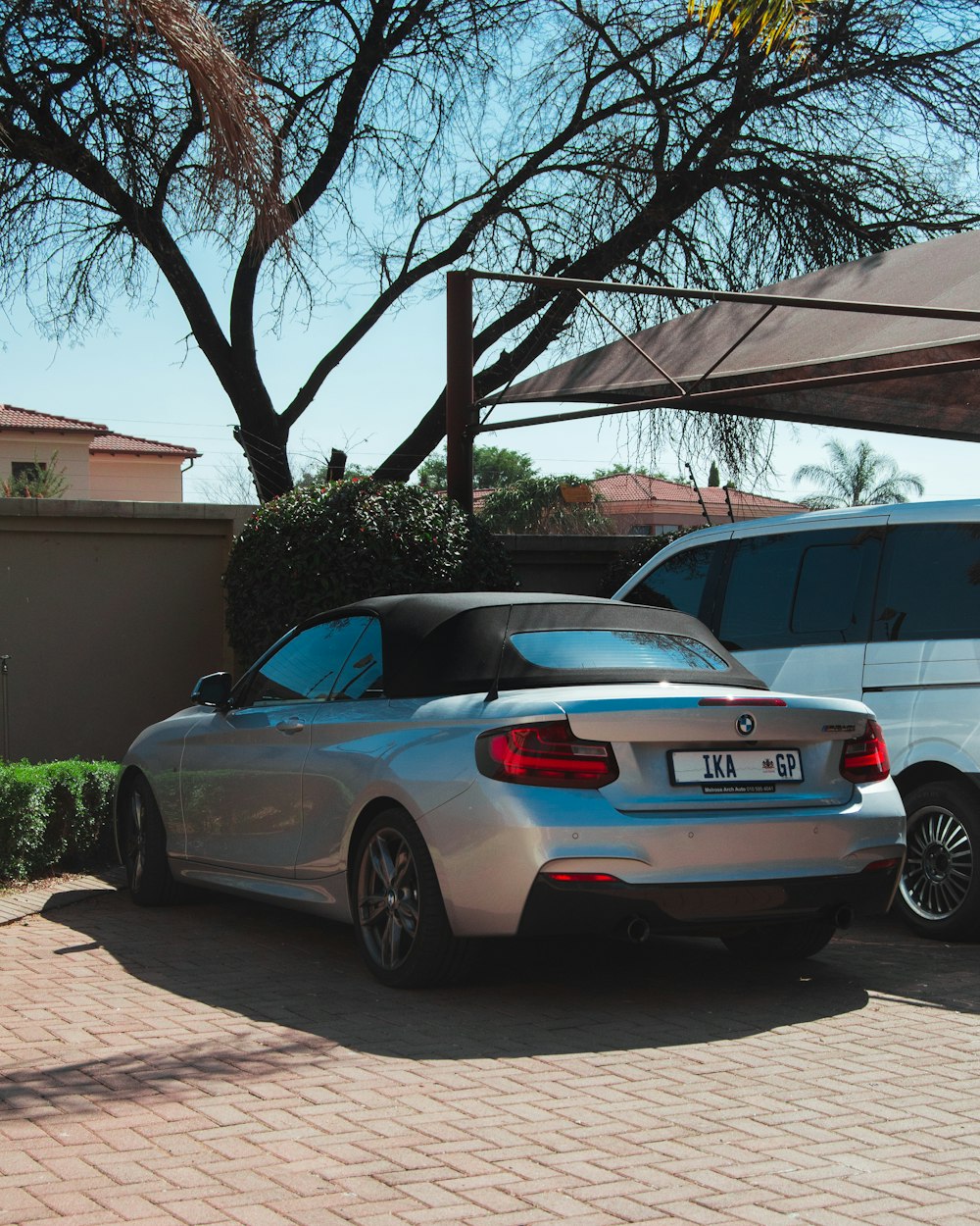 blue bmw coupe parked near white house during daytime