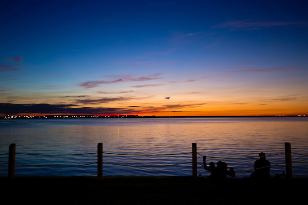 brown wooden dock on sea during sunset