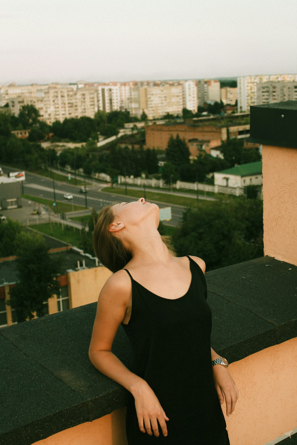 woman in black tank top standing on roof top during daytime