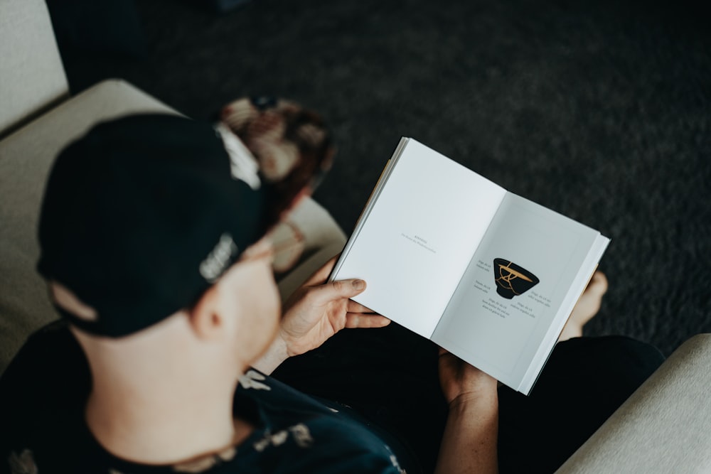 boy in black shirt holding white printer paper