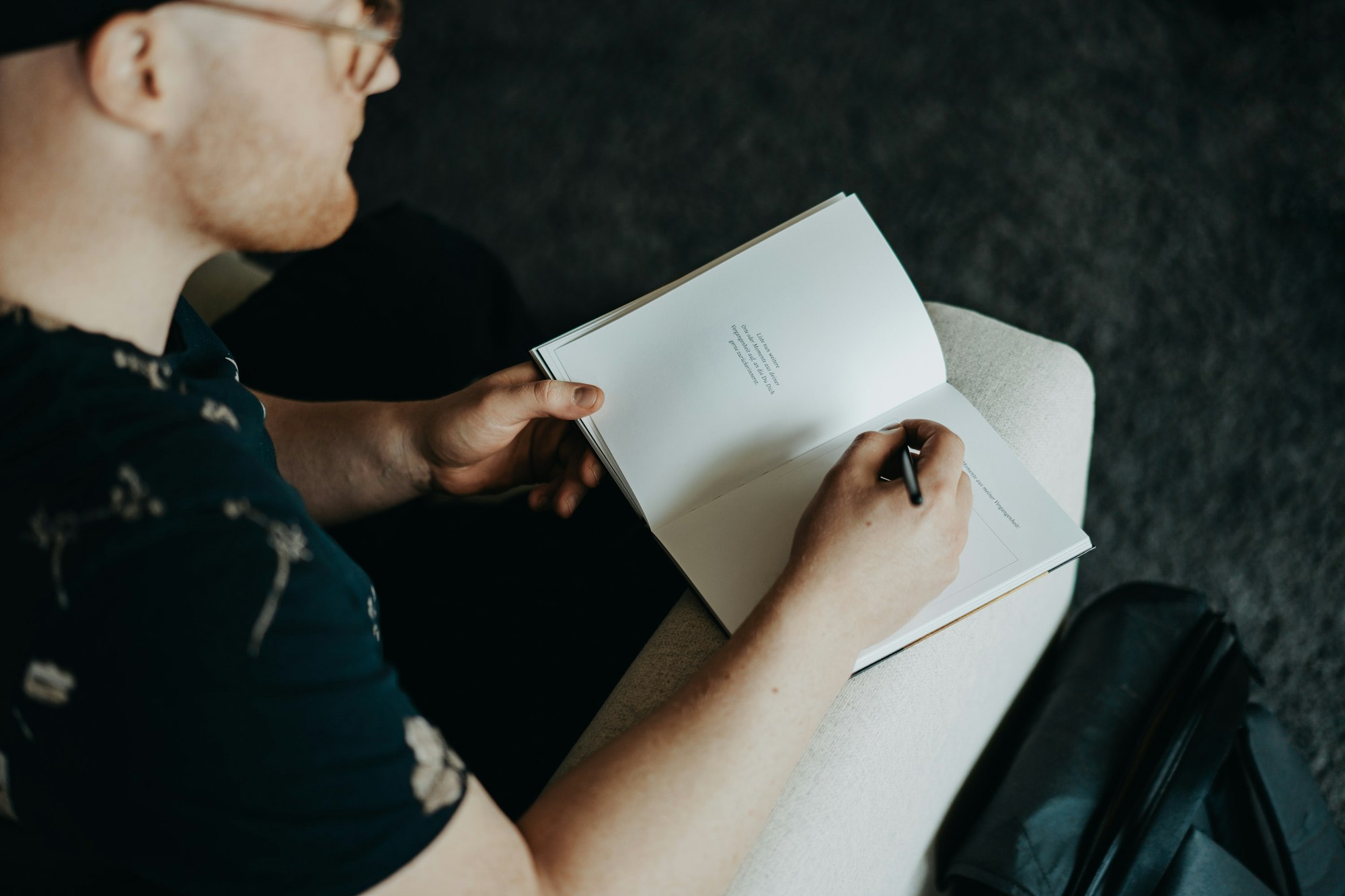 man in black t-shirt holding white printer paper