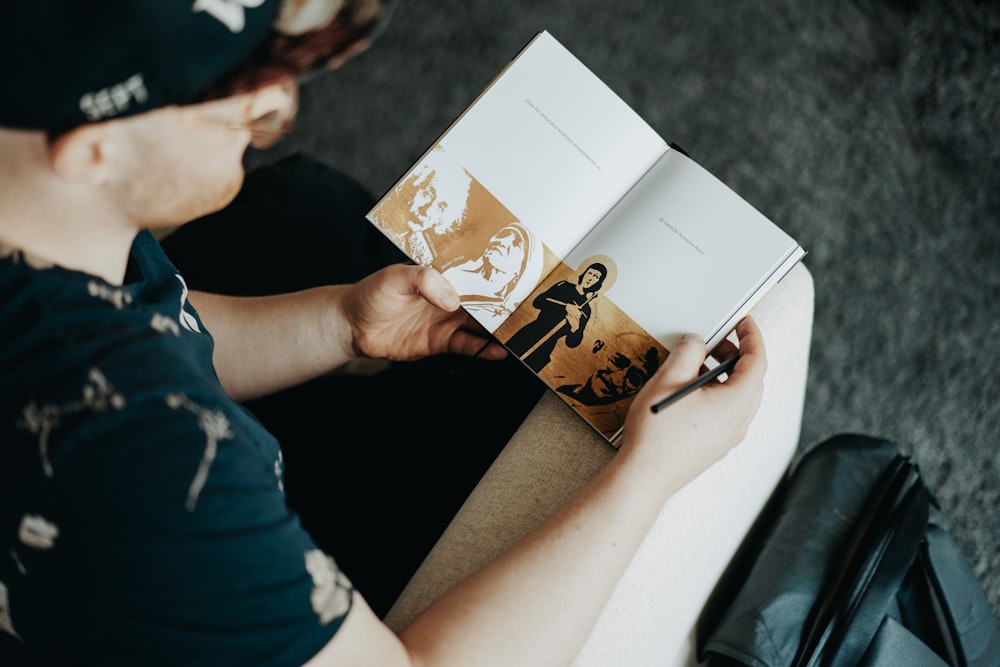 person holding white and brown book