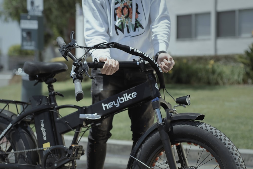 man in white long sleeve shirt riding black bicycle