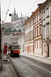 red and white train on rail road near building during daytime