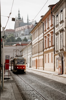 red and white train on rail road near building during daytime