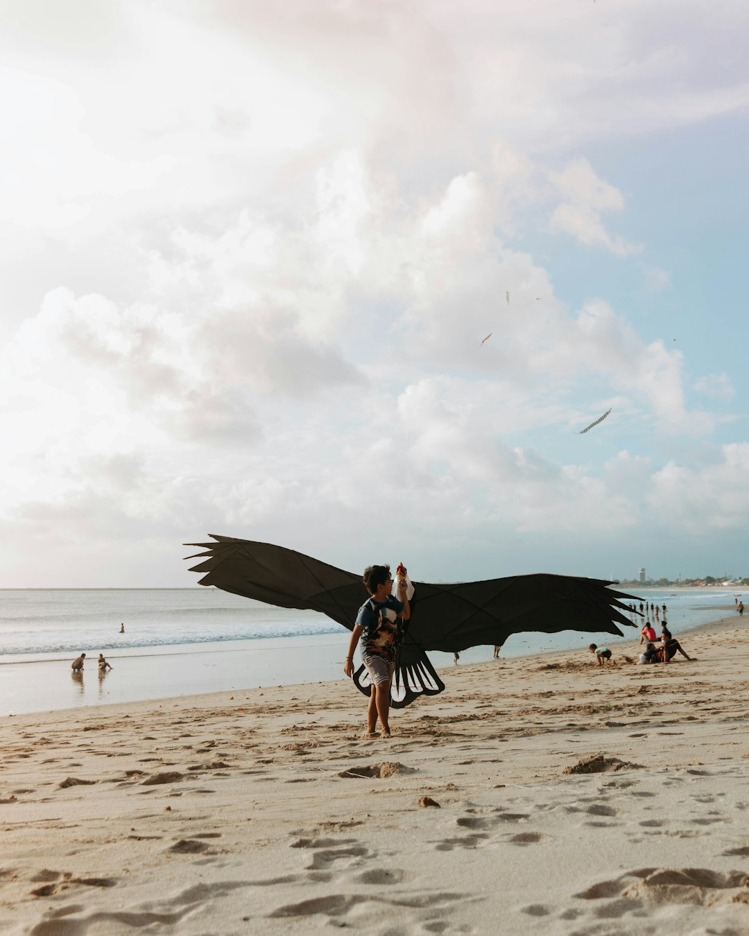 man in black t-shirt and blue denim jeans walking on beach during daytime