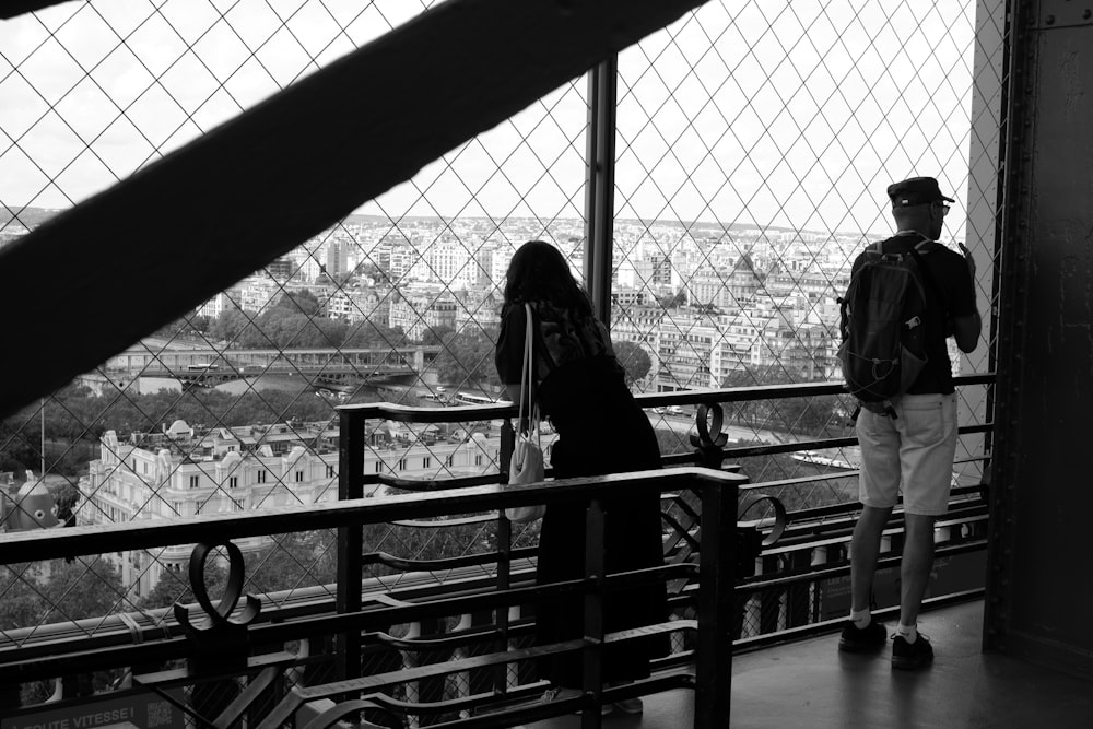 grayscale photo of woman in black jacket standing beside man in white dress shirt