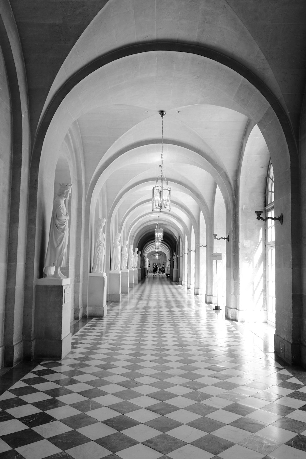 grayscale photo of hallway with columns