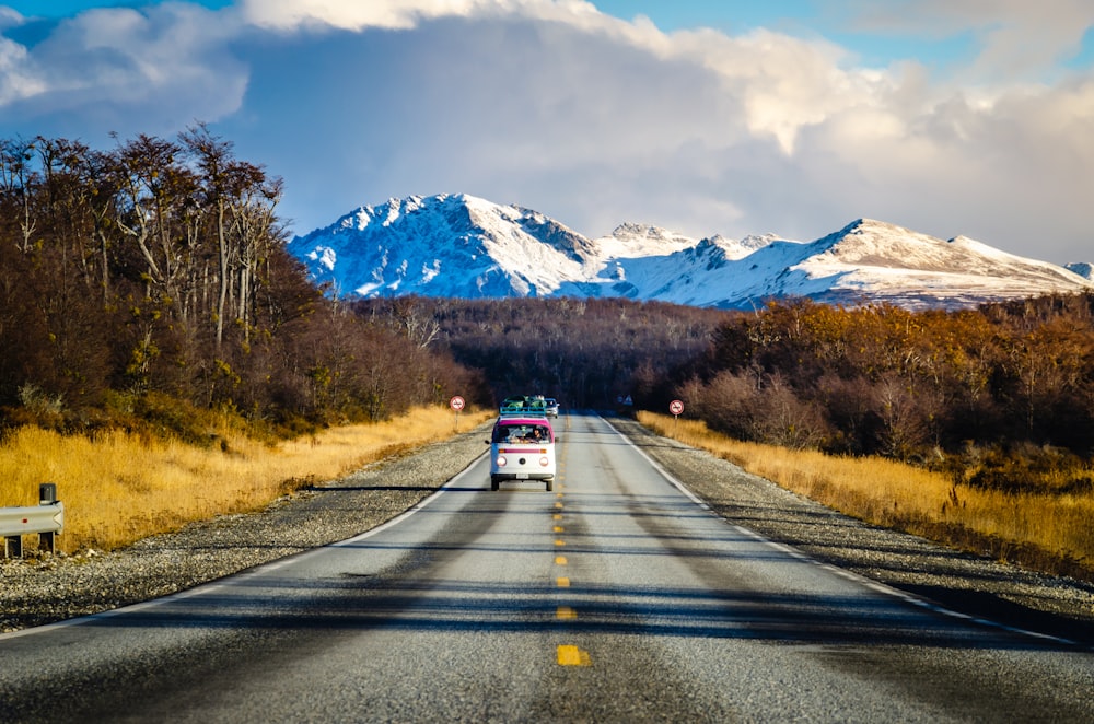 red car on road near mountain range