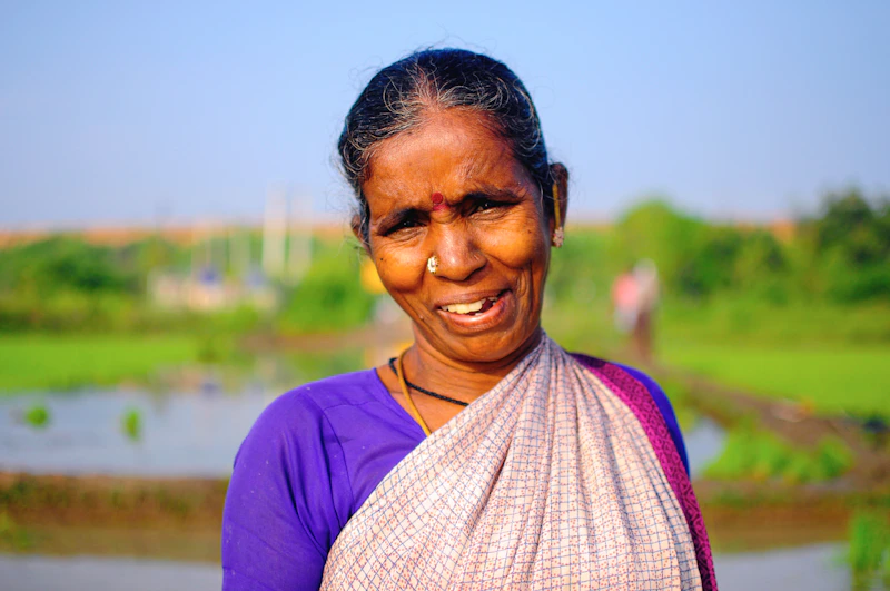 smiling woman in purple shirt wearing white scarf