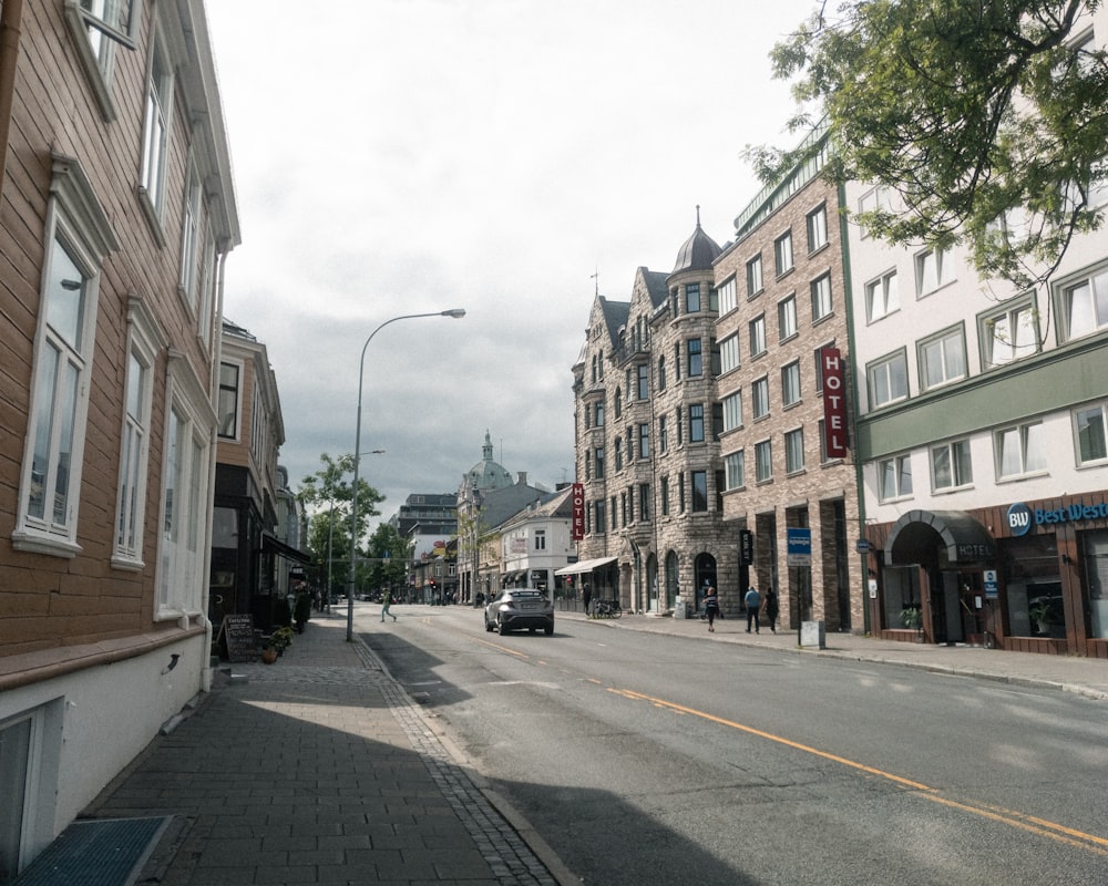 cars parked on side of the road in between buildings during daytime