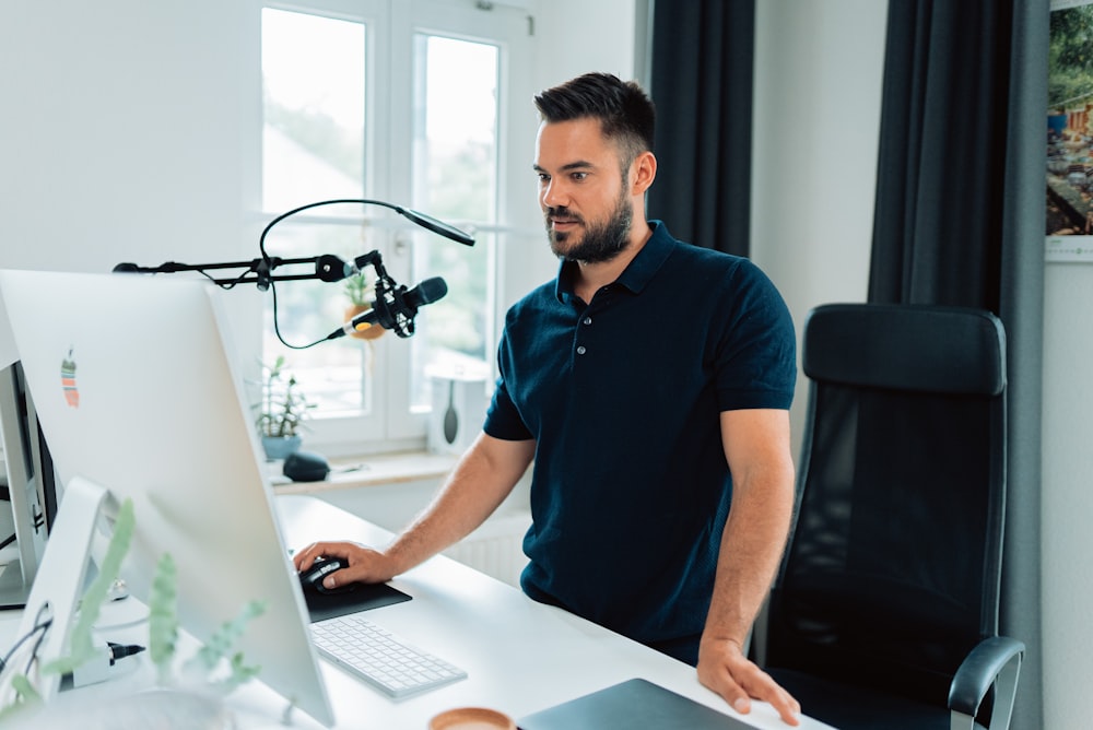 man in blue crew neck t-shirt using macbook