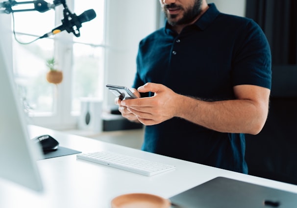 man in blue polo shirt holding silver iphone 6