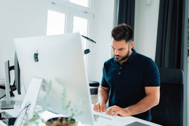 man in blue polo shirt using laptop computer