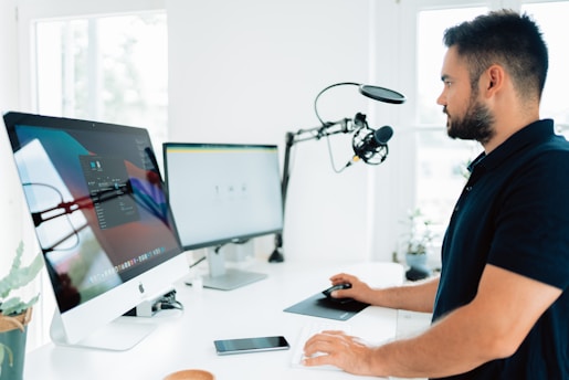 man in blue shirt using computer