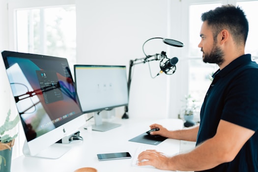 man in blue shirt using computer