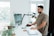 A happy customer using a standing desk in their home office.