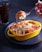 person holding stainless steel fork and yellow bowl with food
