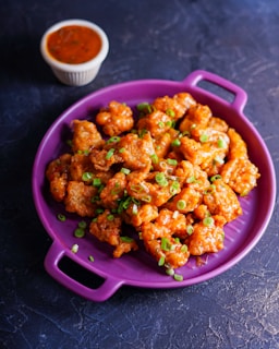 fried food on pink plastic bowl