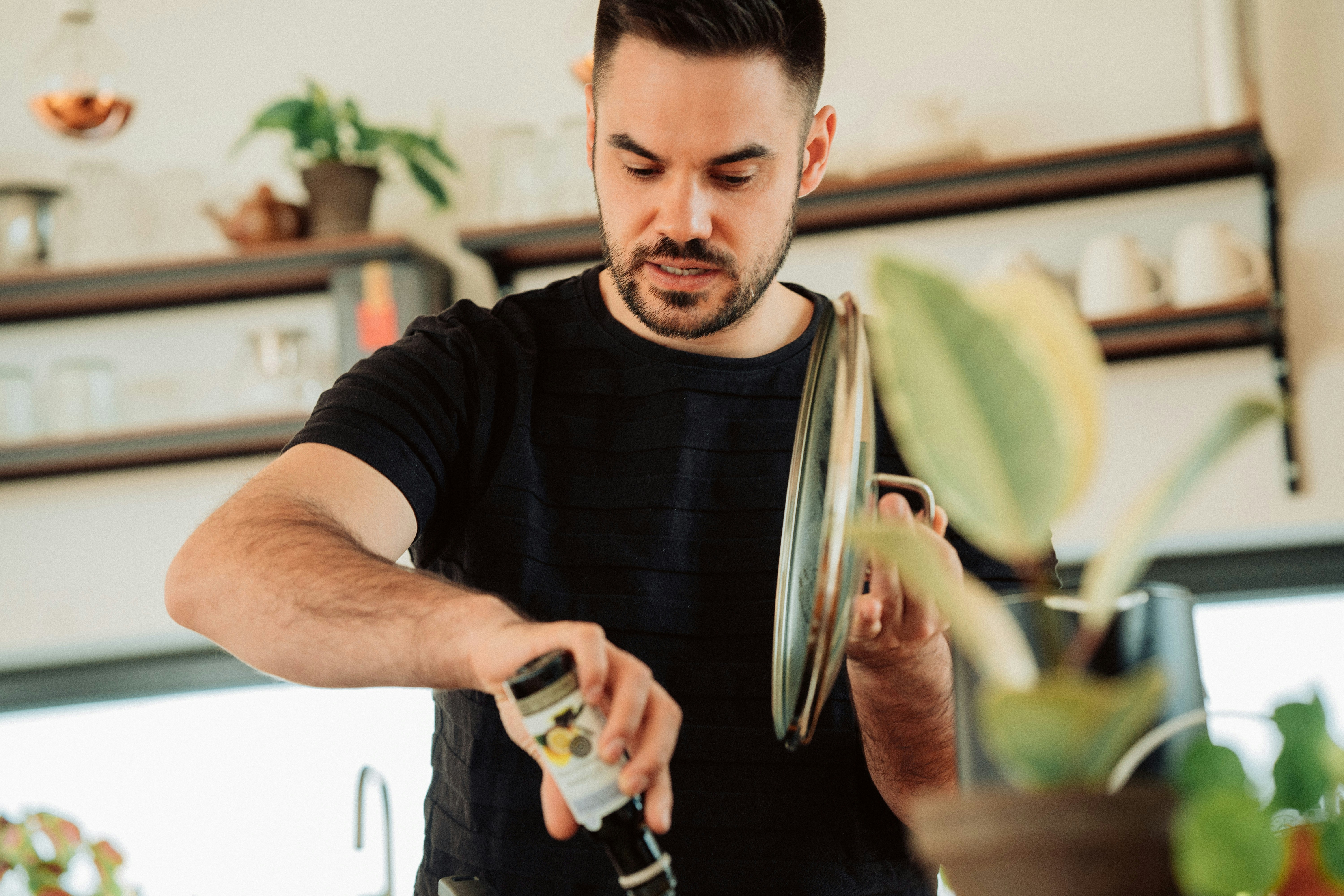 man in black crew neck t-shirt holding silver and black hair clipper