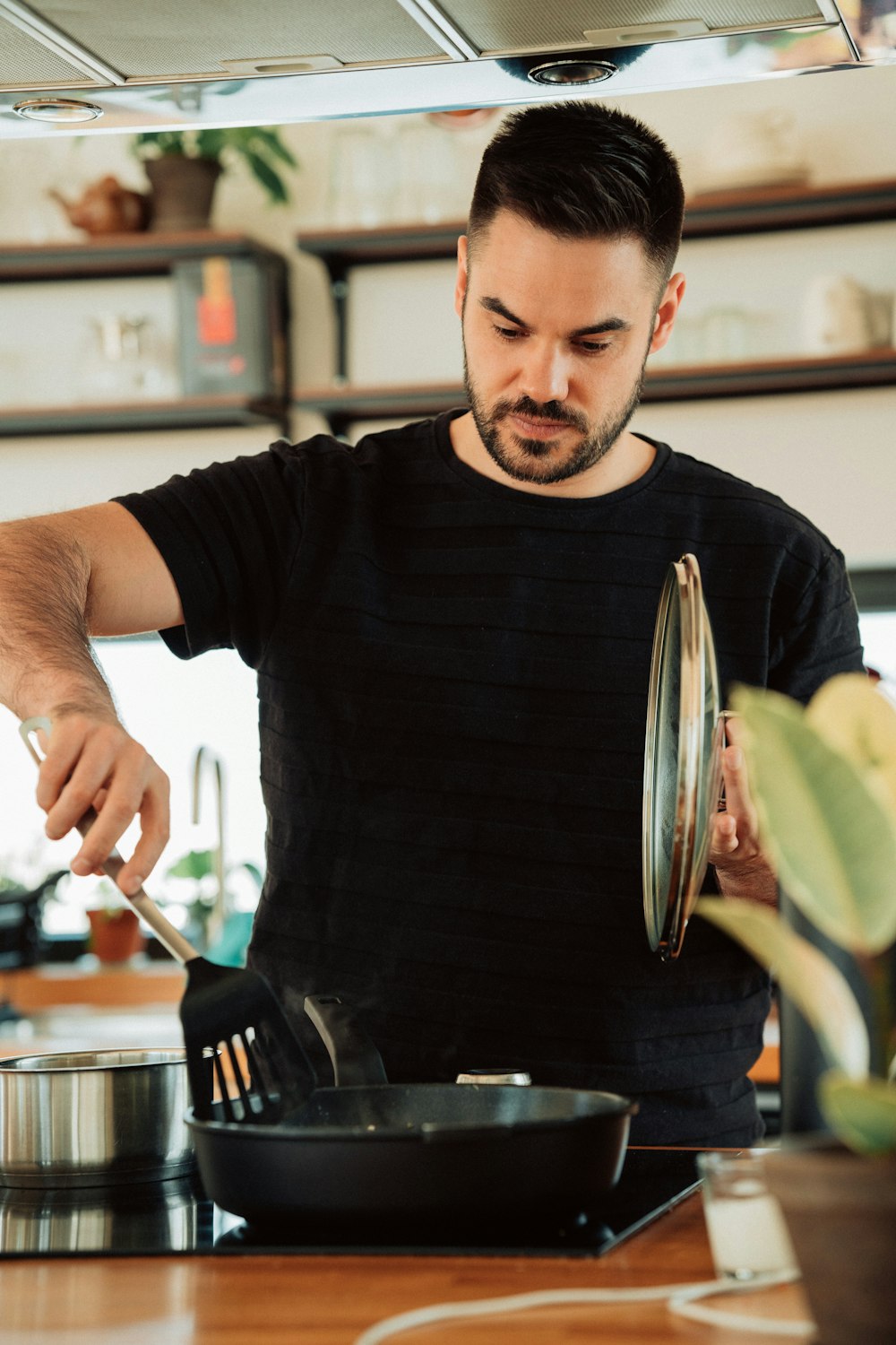 man in black crew neck t-shirt holding stainless steel fork