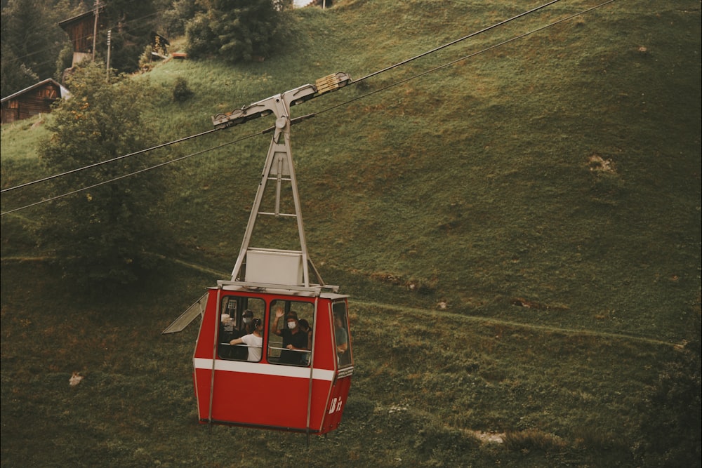 red cable car over green grass field during daytime